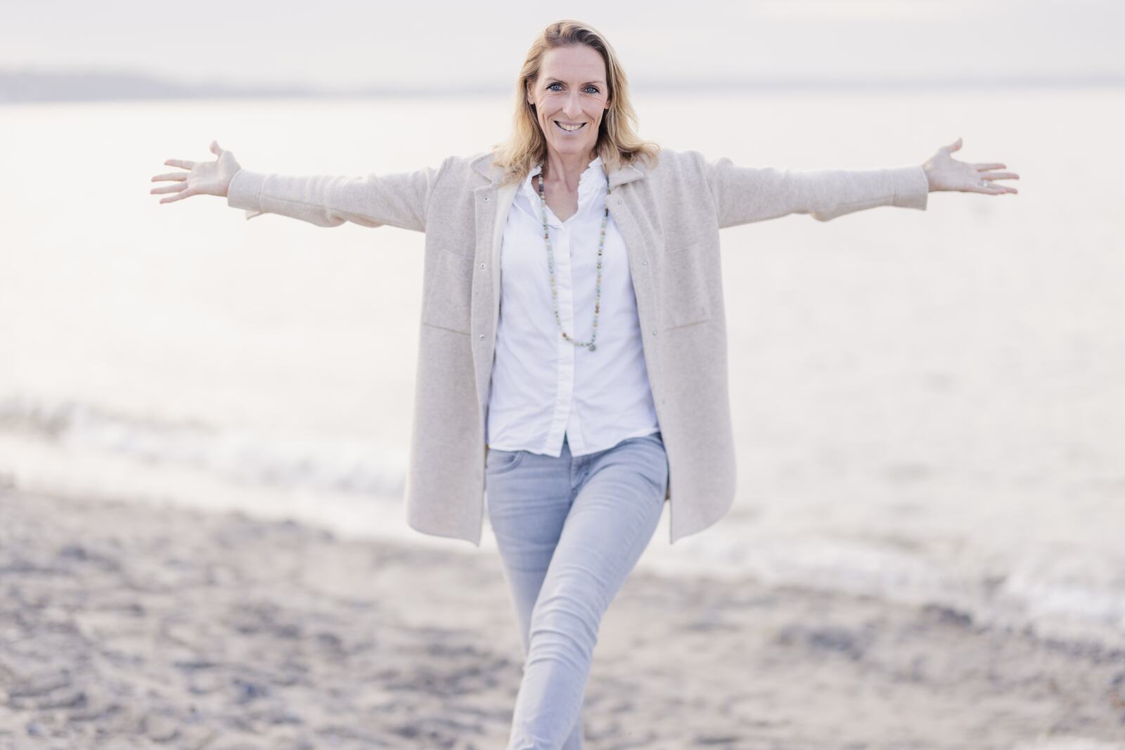 Renée am Strand mit weit geöffneten Armen